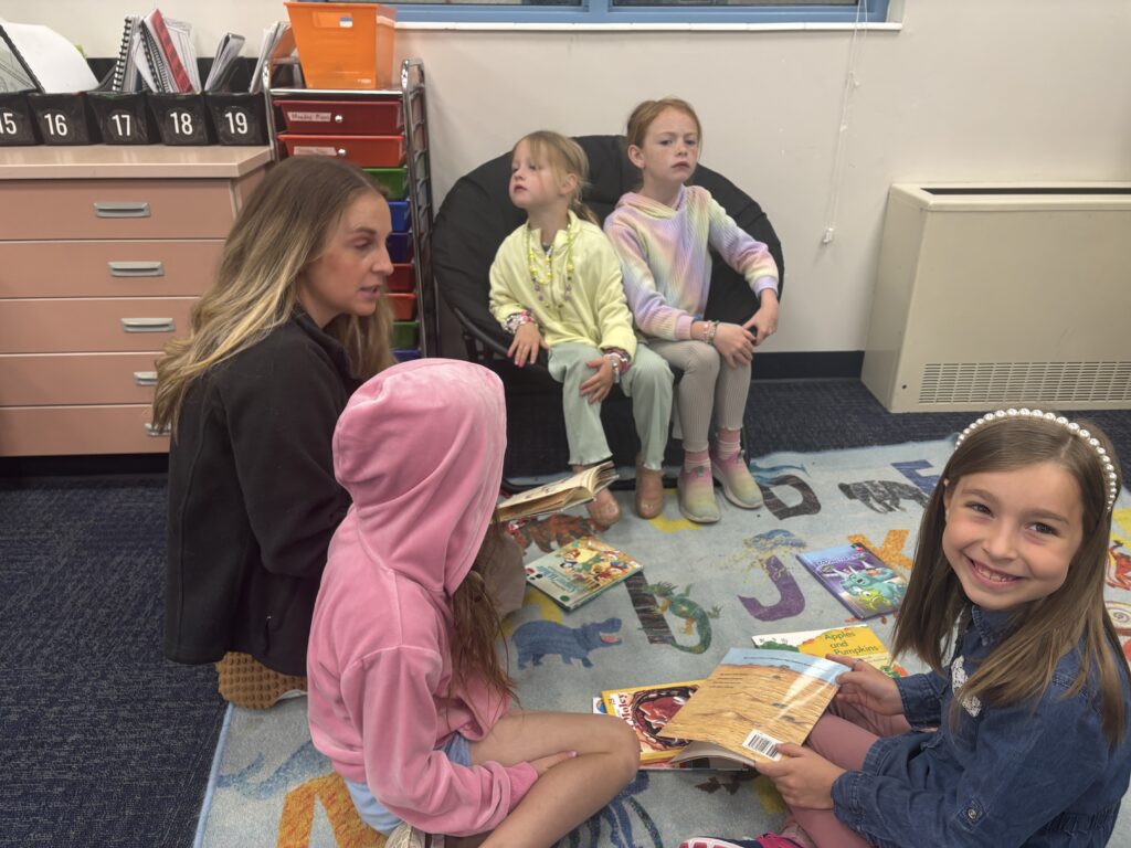 Students reading with  guests that could be parents, grandparents, family friends, or faculty and staff for read with a child day in May
