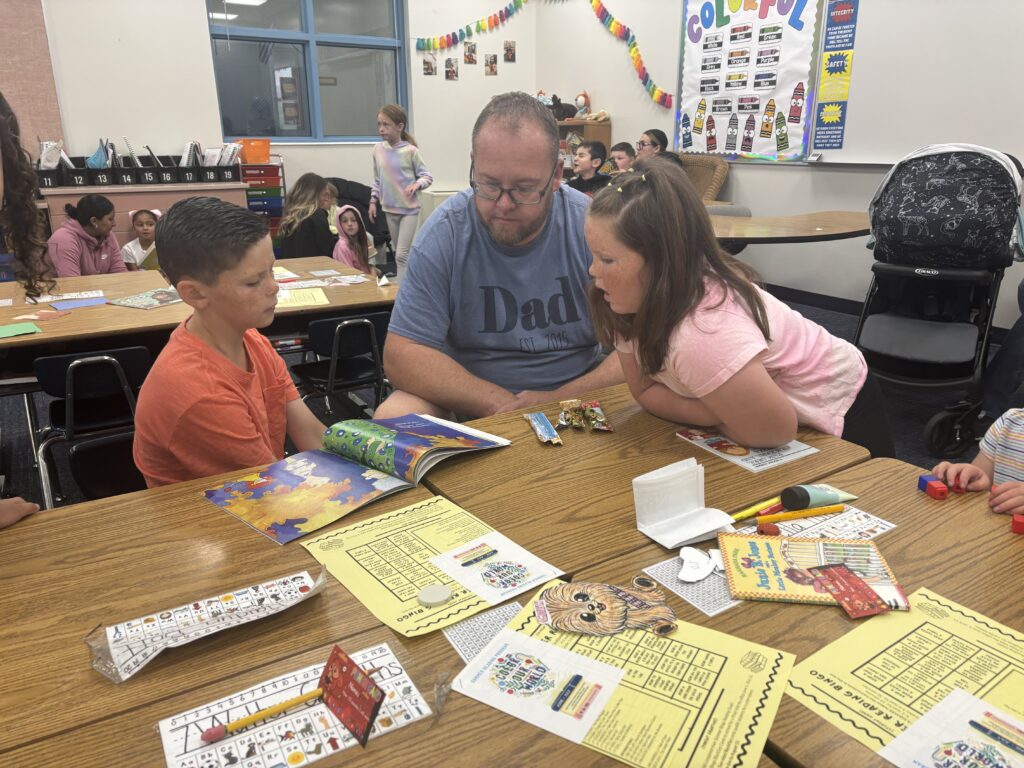 Students reading with  guests that could be parents, grandparents, family friends, or faculty and staff for read with a child day in May
