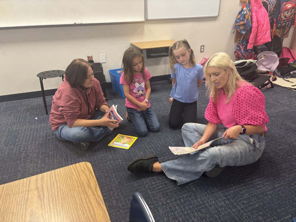 Students reading with  guests that could be parents, grandparents, family friends, or faculty and staff for read with a child day in May