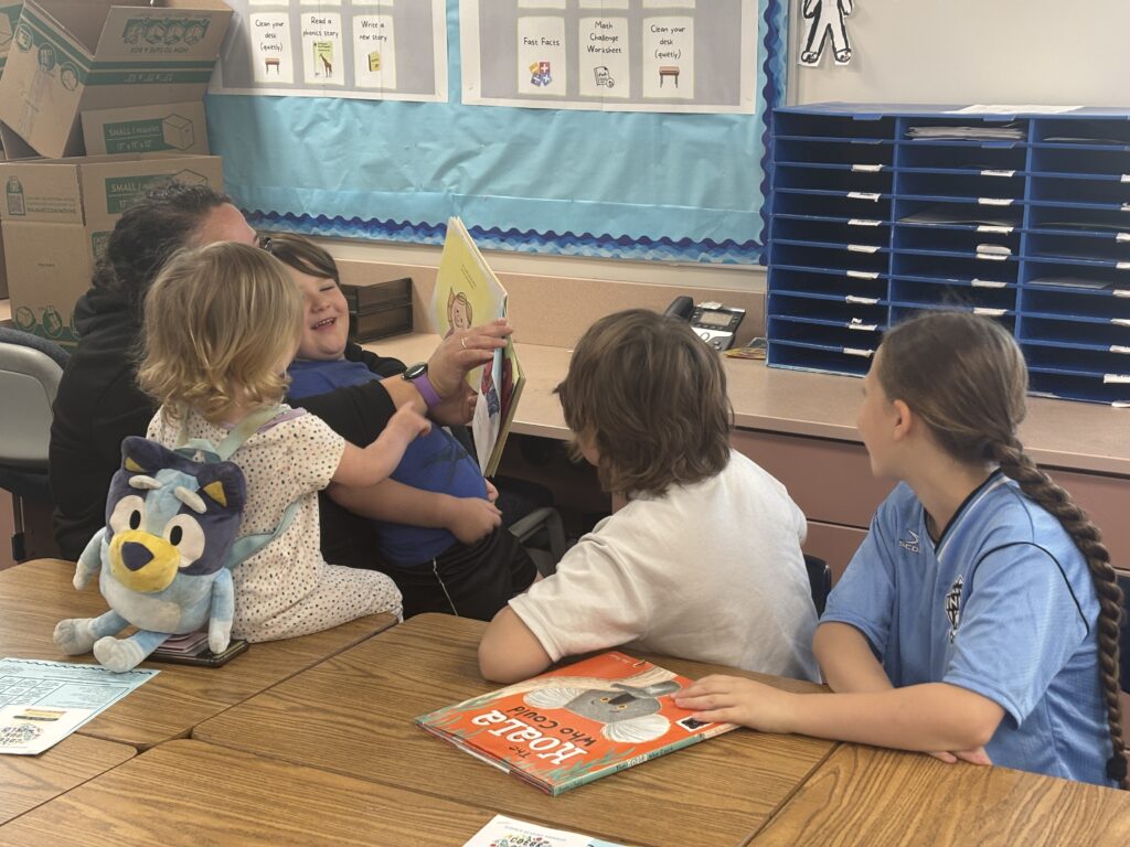 Students reading with  guests that could be parents, grandparents, family friends, or faculty and staff for read with a child day in May