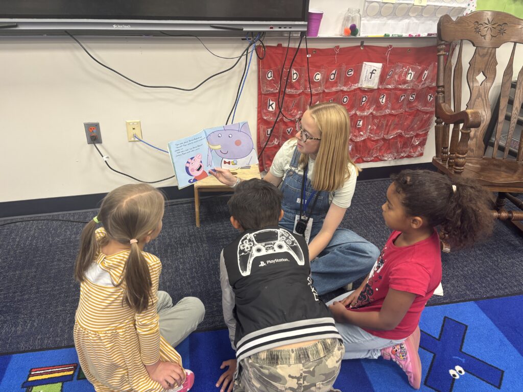 Students reading with  guests that could be parents, grandparents, family friends, or faculty and staff for read with a child day in May
