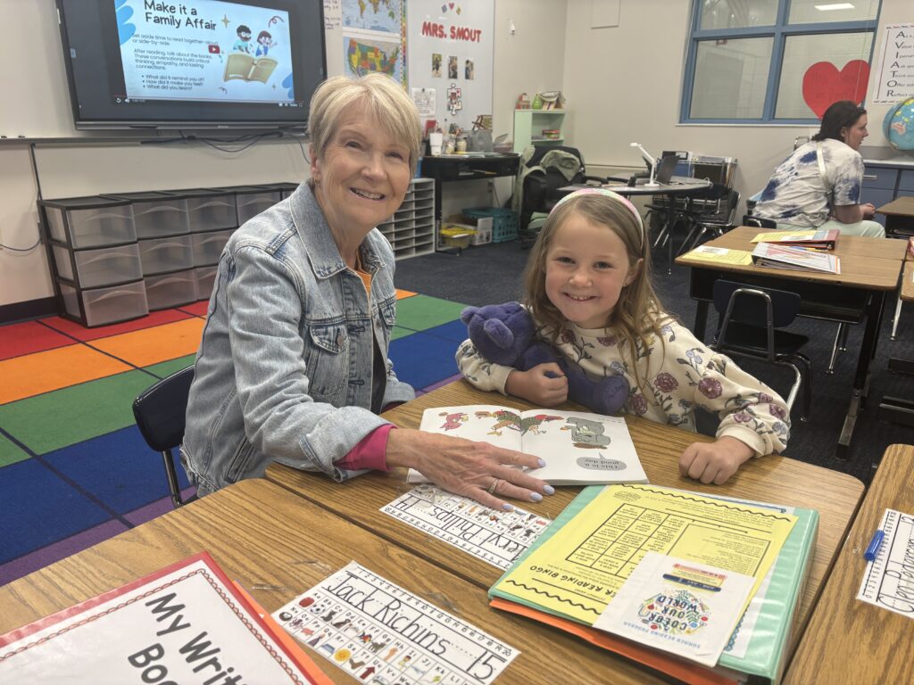 Students reading with  guests that could be parents, grandparents, family friends, or faculty and staff for read with a child day in May