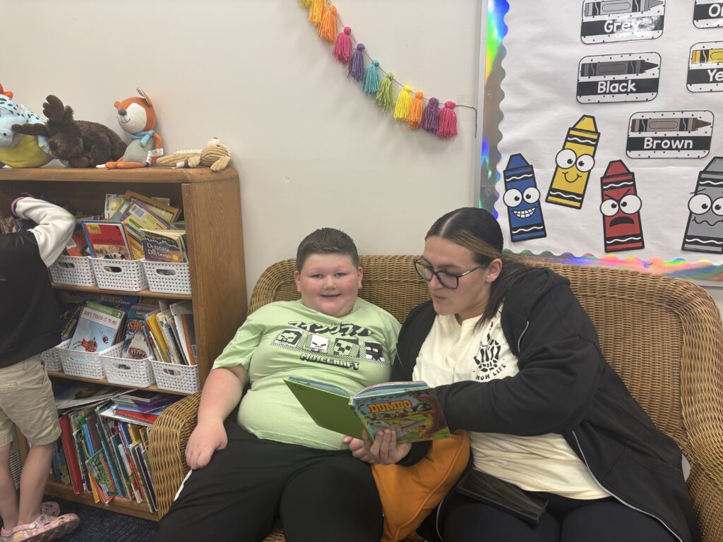 Students reading with  guests that could be parents, grandparents, family friends, or faculty and staff for read with a child day in May