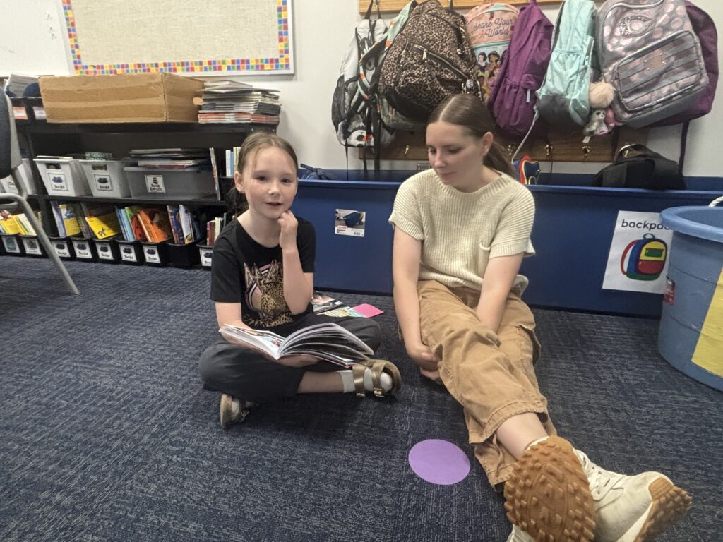Students reading with  guests that could be parents, grandparents, family friends, or faculty and staff for read with a child day in May