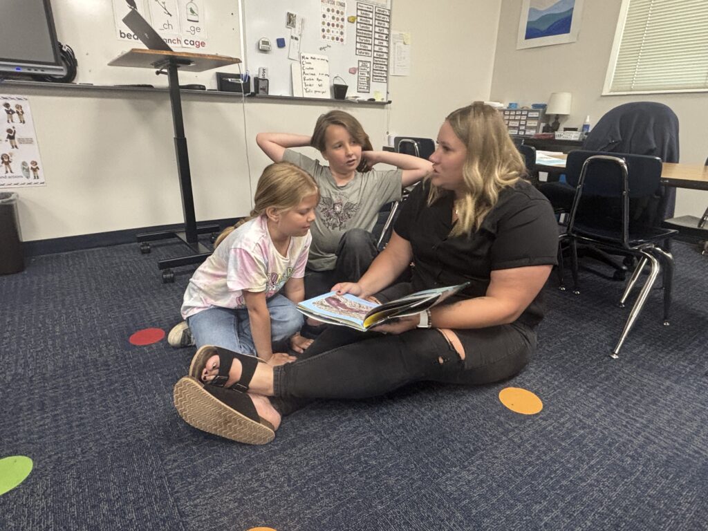 Students reading with  guests that could be parents, grandparents, family friends, or faculty and staff for read with a child day in May