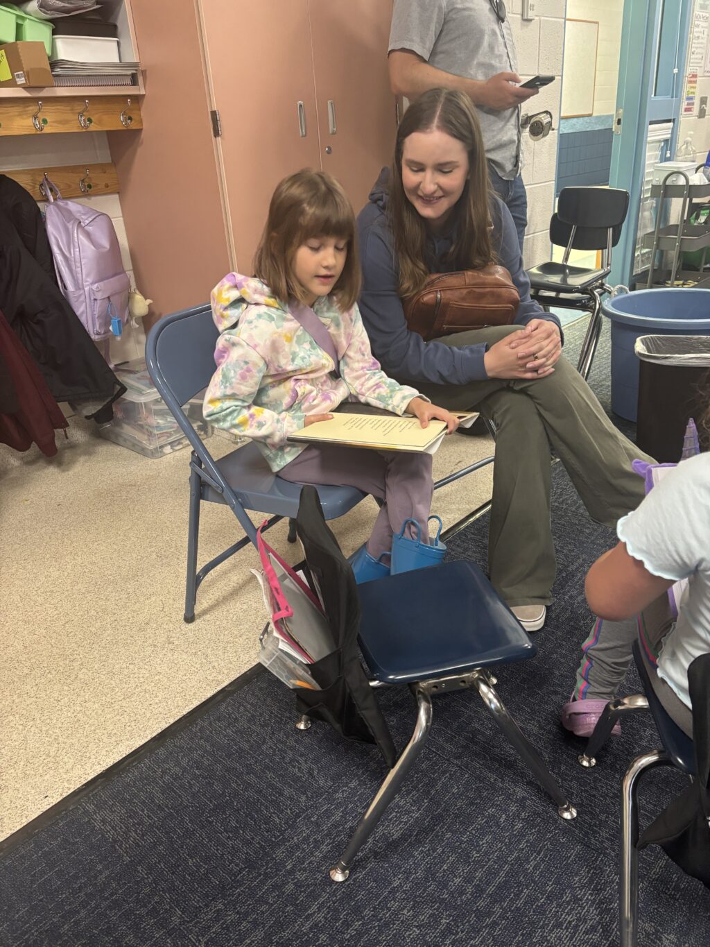 Students reading with  guests that could be parents, grandparents, family friends, or faculty and staff for read with a child day in May